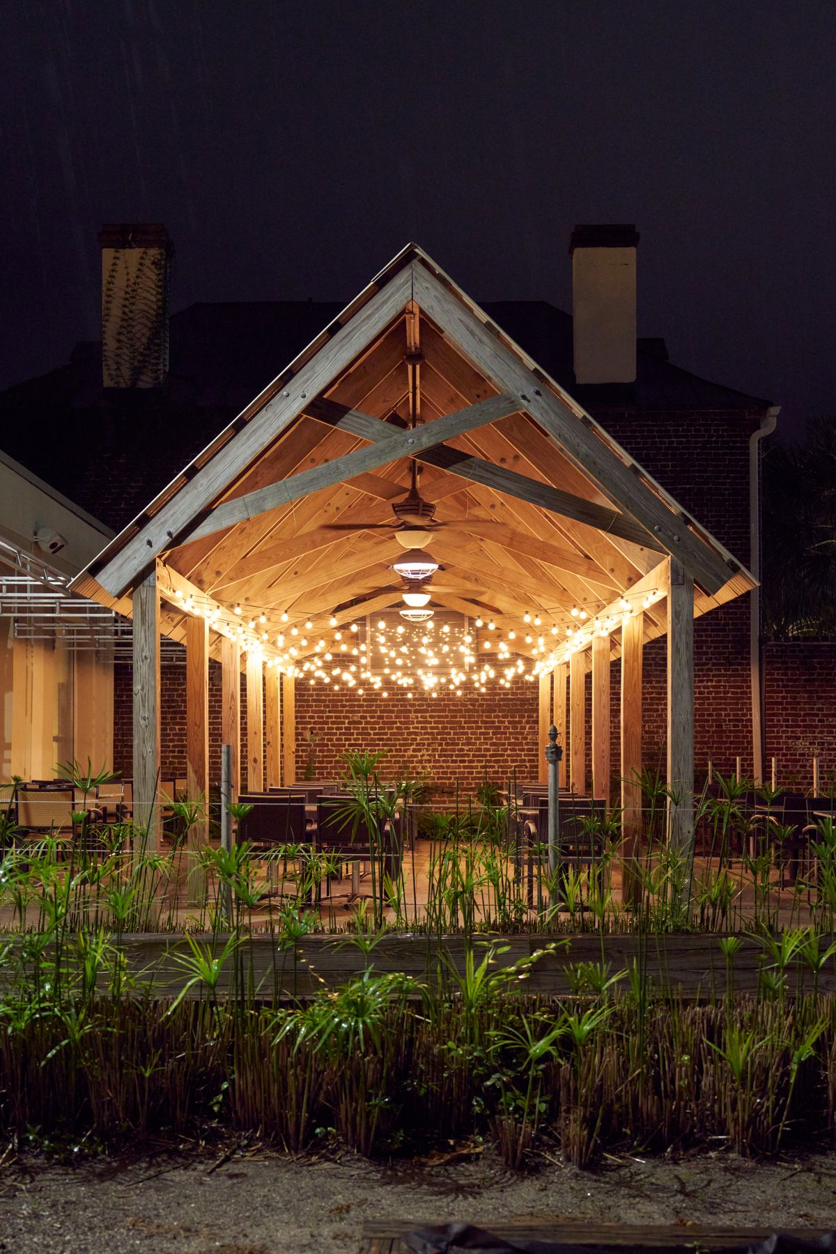 Saffron's illuminated outdoor dining area at dusk in Charleston